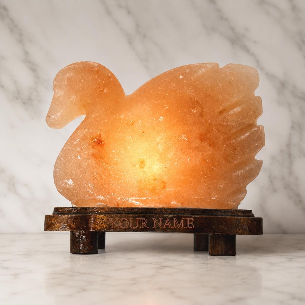 Duck Himalayan Salt Lamp glowing warm pink on a wooden surface