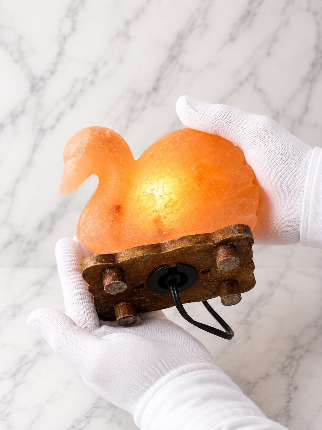Duck Himalayan Salt Lamp glowing warm pink on a wooden surface