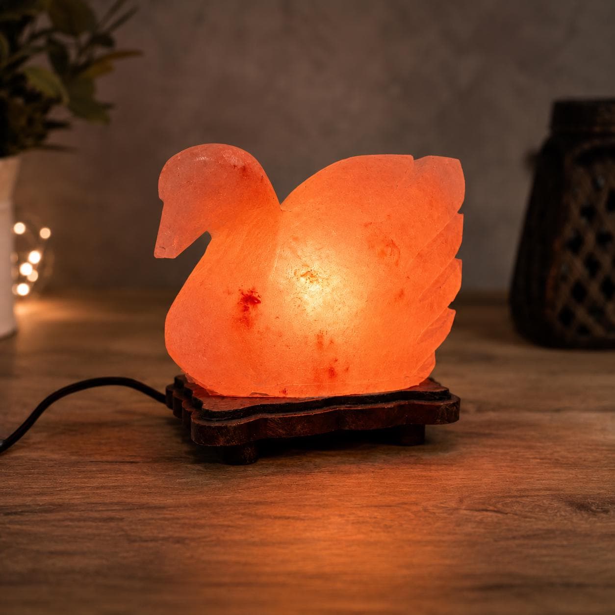 Duck Himalayan Salt Lamp glowing warm pink on a wooden surface