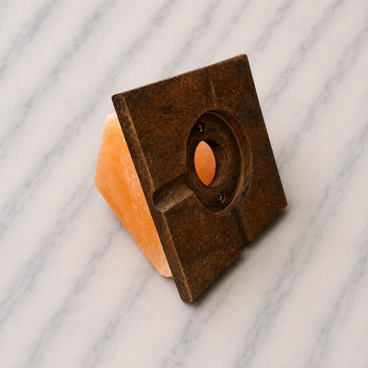 Pyramid Himalayan Salt Lamp glowing warm amber on a wood surface