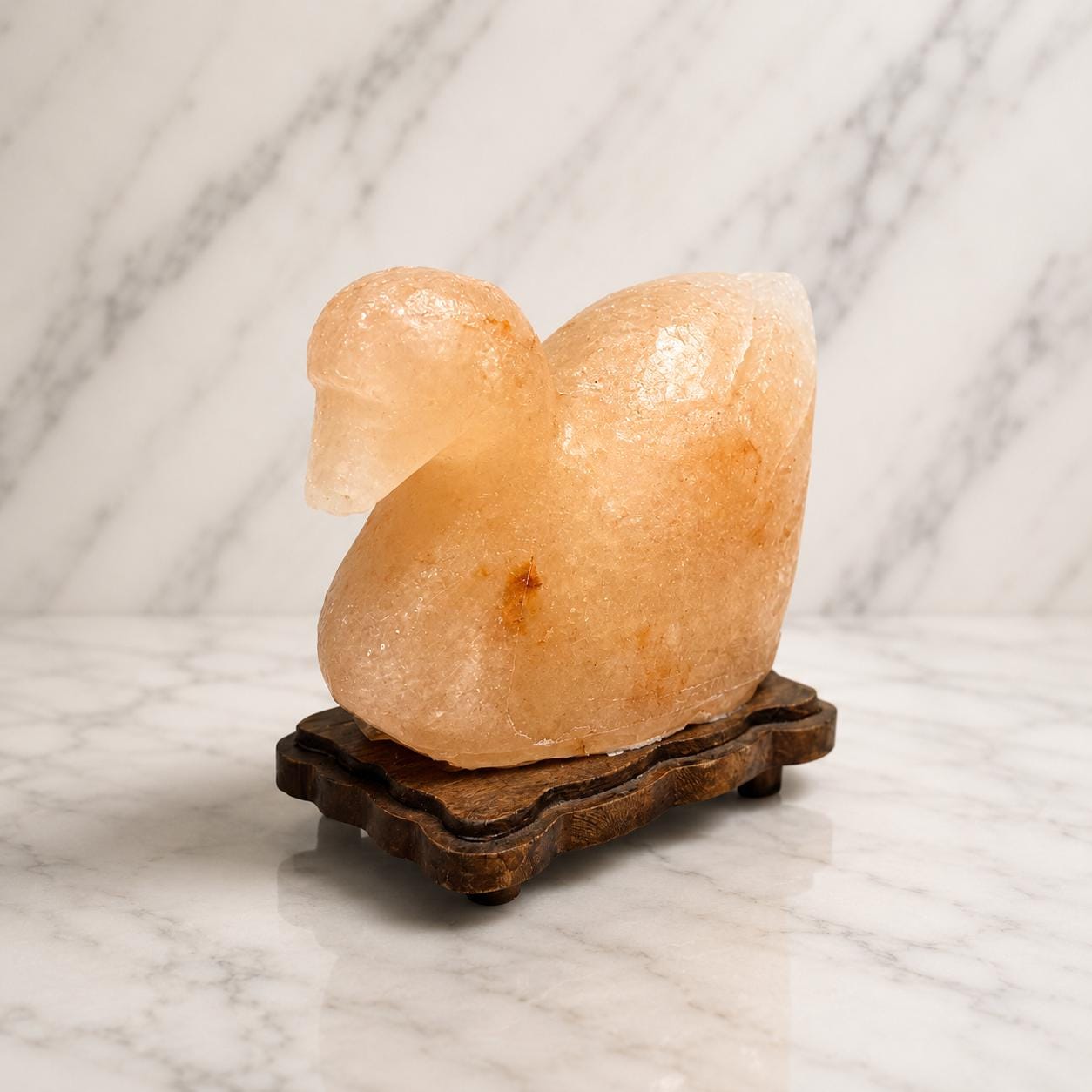 Duck Himalayan Salt Lamp glowing warm pink on a wooden surface