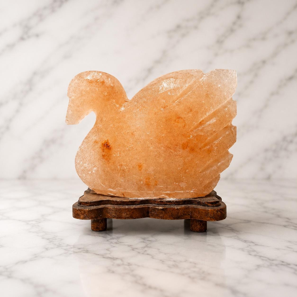 Duck Himalayan Salt Lamp glowing warm pink on a wooden surface