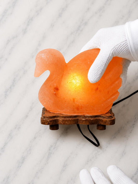 Duck Himalayan Salt Lamp glowing warm pink on a wooden surface