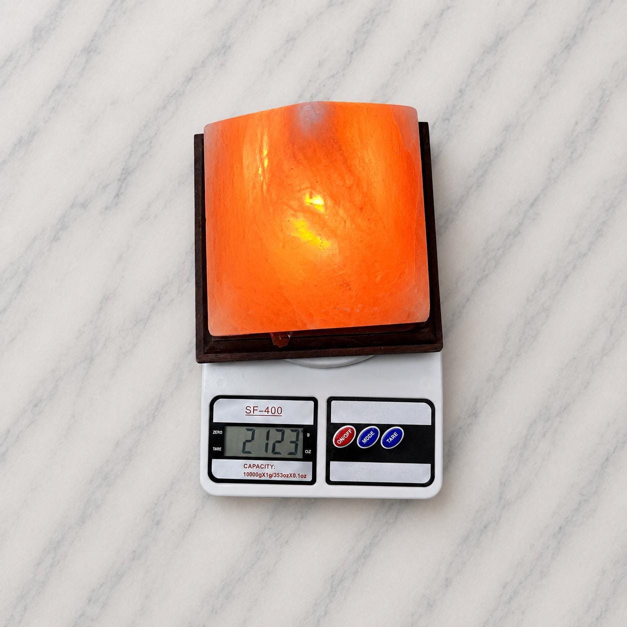 Pyramid Himalayan Salt Lamp glowing warm amber on a wood surface