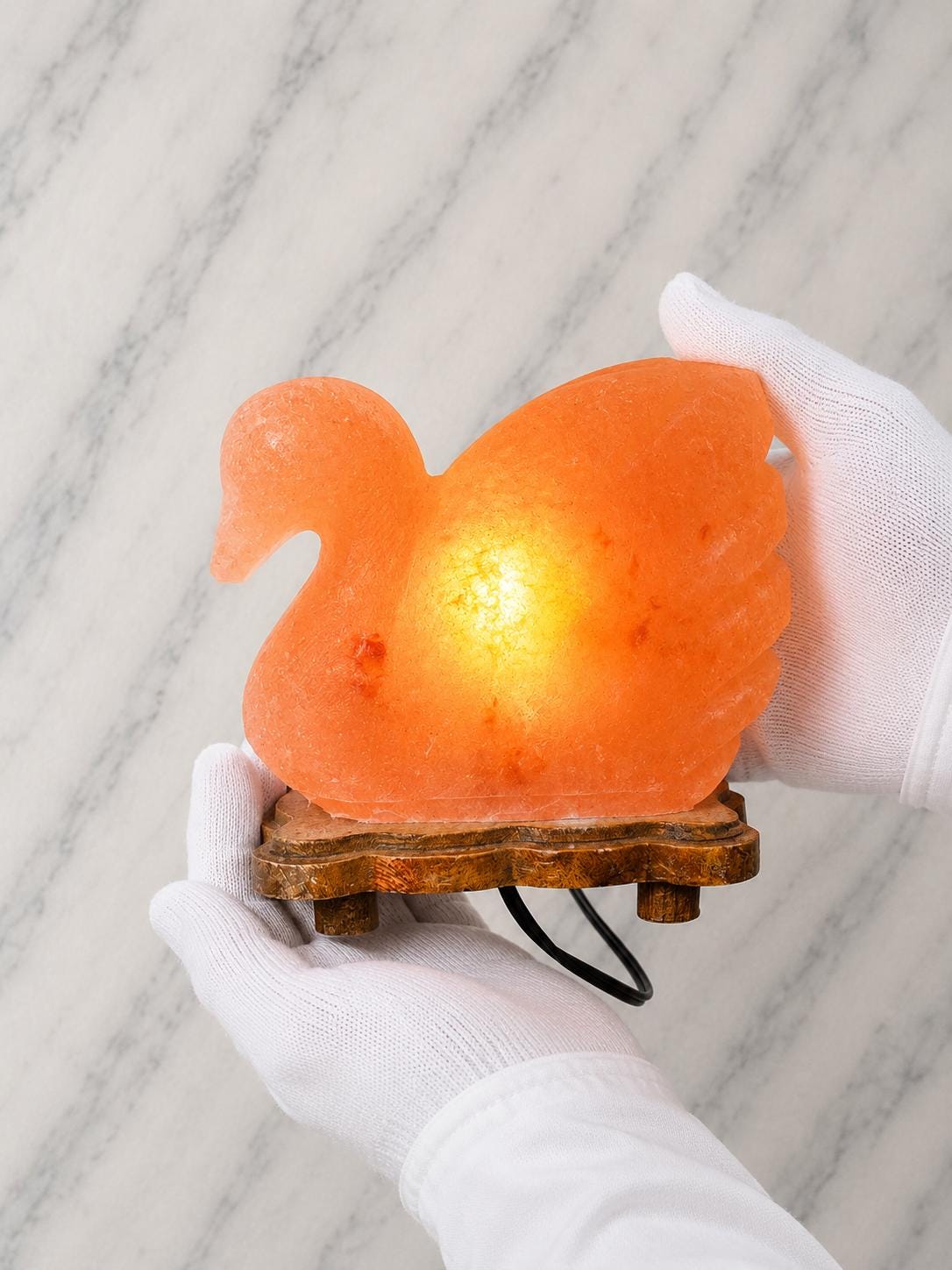 Duck Himalayan Salt Lamp glowing warm pink on a wooden surface
